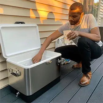 man reaching in to a stainless steel cooler