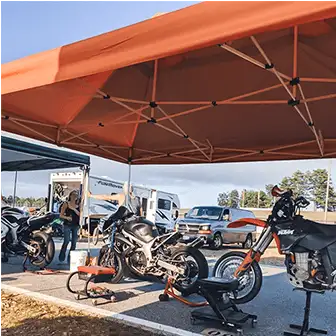 motorcycles parked underneath a pop-up canopy